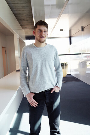 Das Bild zeigt einen Jungen Mann, der im Verwaltungsgebäude der MATTHÄUS SCHMID Gruppe steht. Er ist Student in Biberach an der Riß und absolviert aktuell bei Schmid sein Praxissemester.